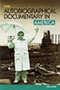 The Autobiographical Documentary in America: cover art of a man holding an umbrella, colored monochromatic green, standing in front of an industrial yard.