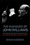 The Film Music of John Williams: a black cover revealing a grayscale photograph of John Williams conducting. The title text is proclaimed in capitalized blue text with a thin line separating it from the red subtitle text. Photograph by Walter H. Scott. Design by Jennifer Conn.