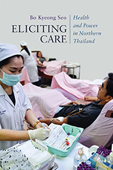 Eliciting Care: Two nurses in light blue each care for a row of patients in hospital beds with pink sheets.