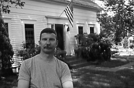 photo of Mark Sammons in front of a colonial house